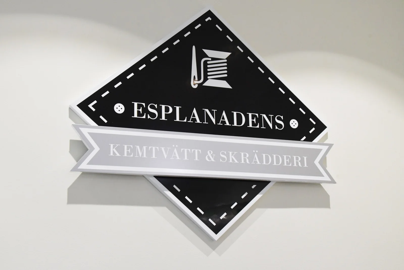 Esplanadens diamantformade logotyp på en vit vägg